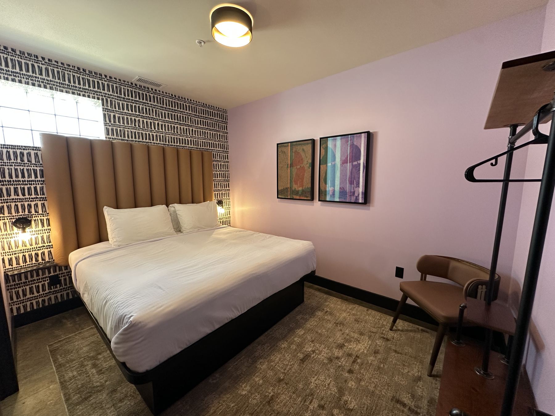 King bedroom with channel-tufted headboard and gallery wall