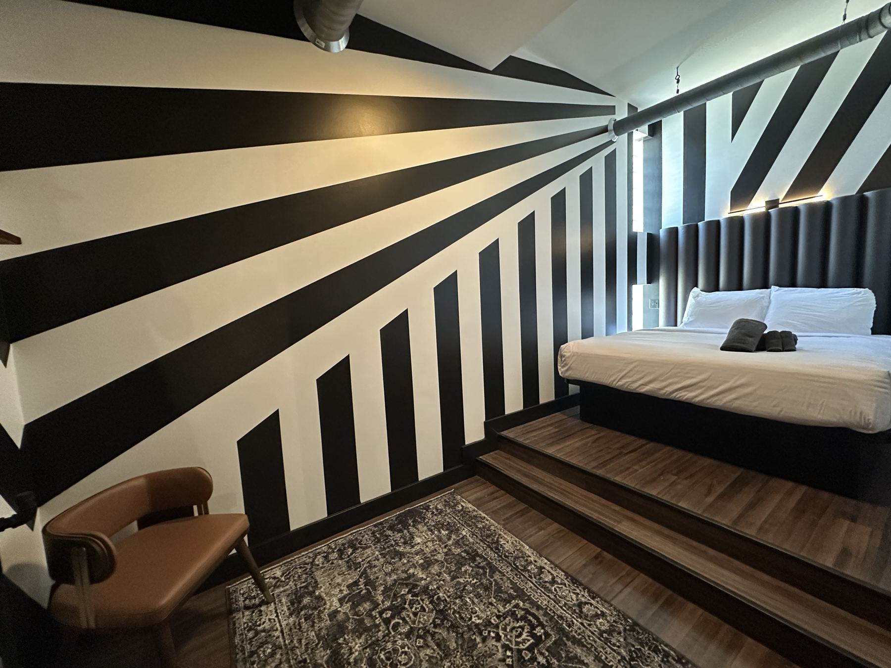 King bedroom with black and white stripe mural