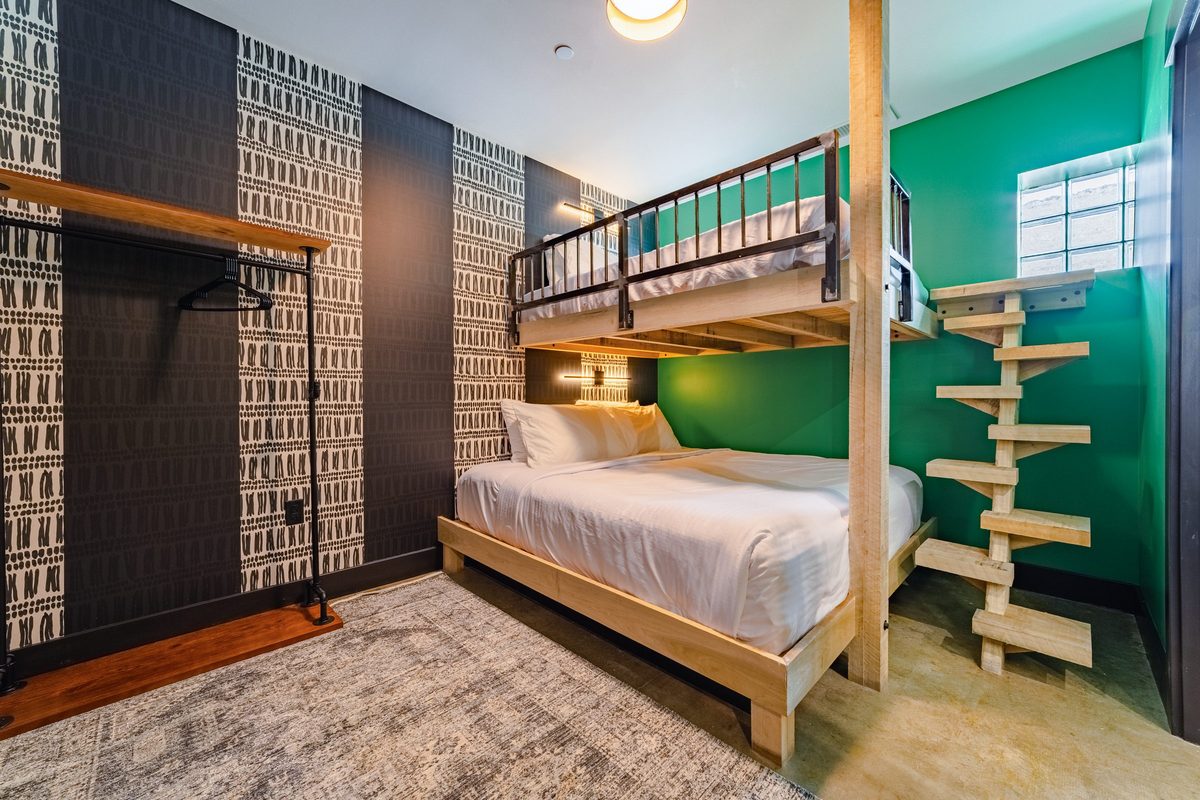 Queen over king bunk room with patterned wallpaper
